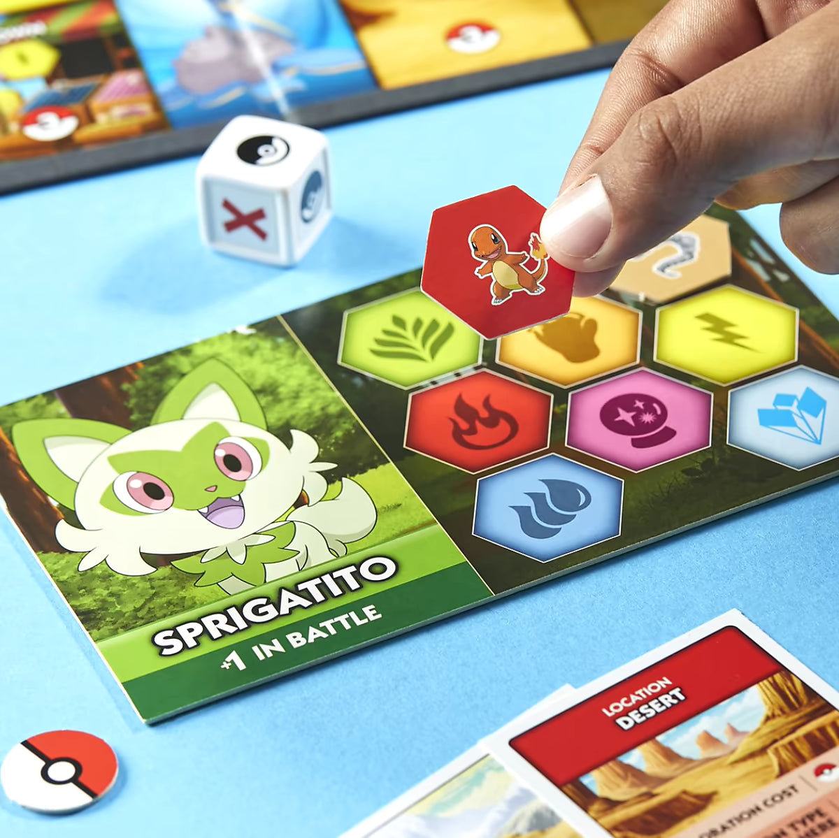 Detailfoto Monopoly Pokémon bordspel met speler die Charmander fiche plaatst op Sprigatito spelerskaart tijdens het spel.