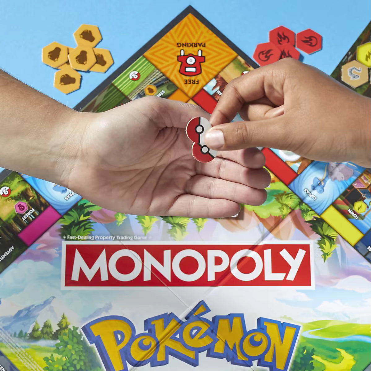 Detailfoto van Monopoly Pokémon familiespel met handen die rode Pokéball fiches doorgeven tijdens het bordspel.