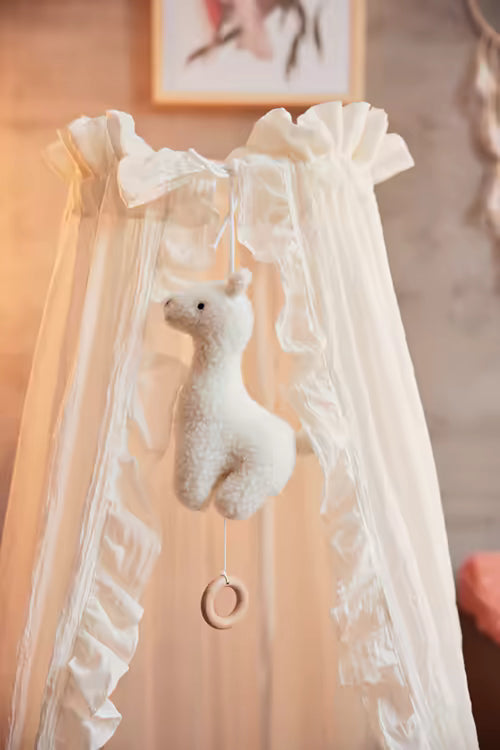 Witte Jollein Muziekdoosje Lama met houten ring, hangend in lichte babykamer, sfeervolle muziekdoosje baby muziekhanger.