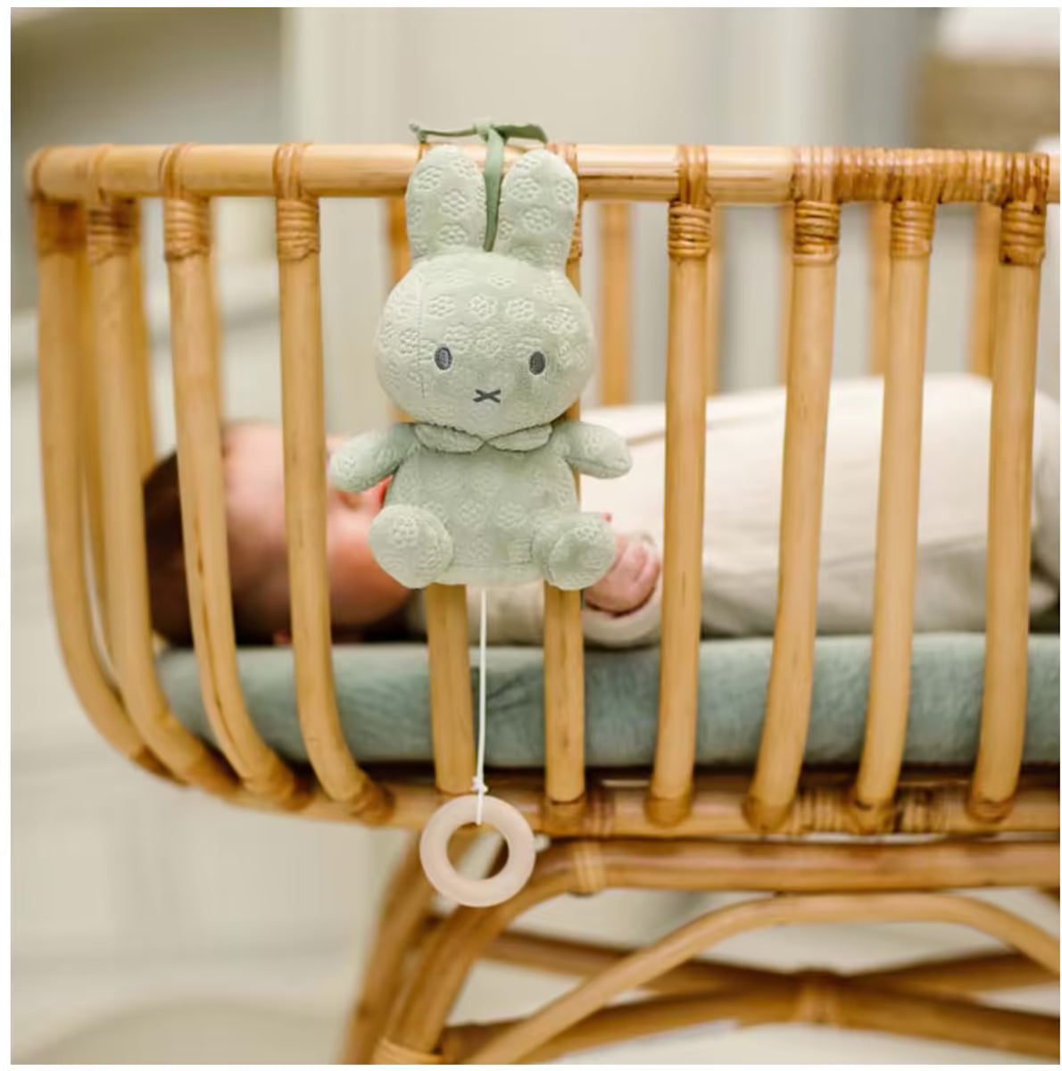 Muziekdoosje Nijntje green flower met trekkoord en houten ring, bevestigd aan rieten wieg, ideaal baby cadeau.