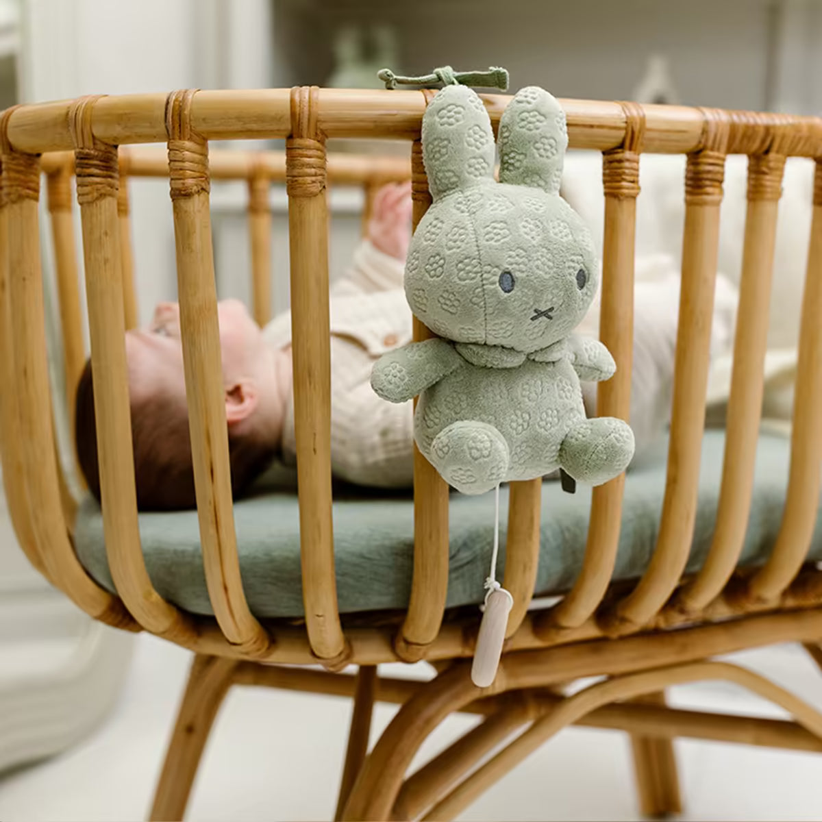 Muziekdoosje Nijntje green flower in zachte stof, bevestigd aan een houten wieg, ideaal sensorisch speelgoed voor baby’s.