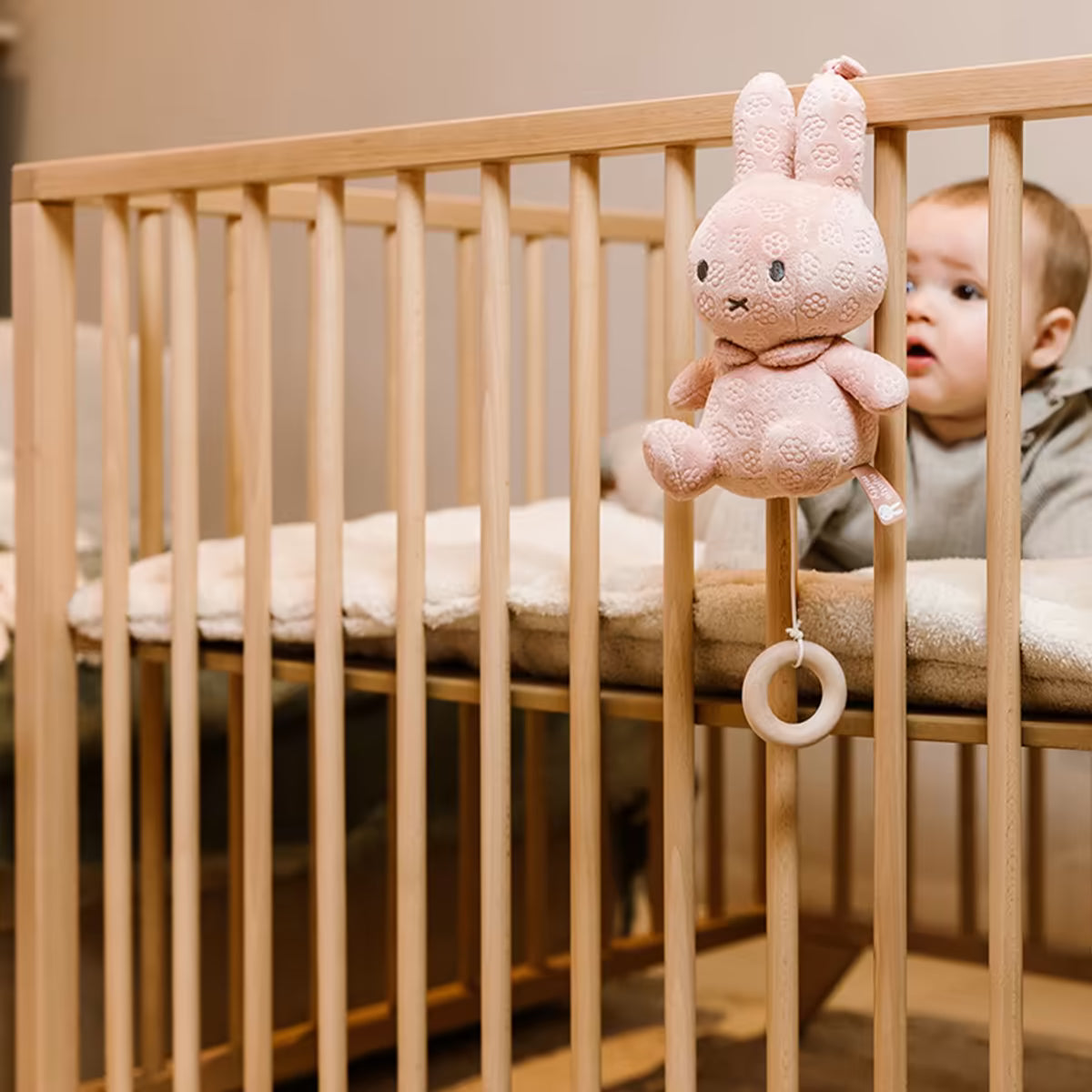 Muziekdoosje Nijntje Pink flower bevestigd aan houten ledikant, zacht kraamcadeau voor pasgeboren baby.