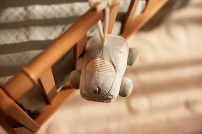 Blauw Jollein Muziekdoosje On The Go in auto vorm, bevestigd aan houten wieg, zacht muziekhanger voor baby’s.