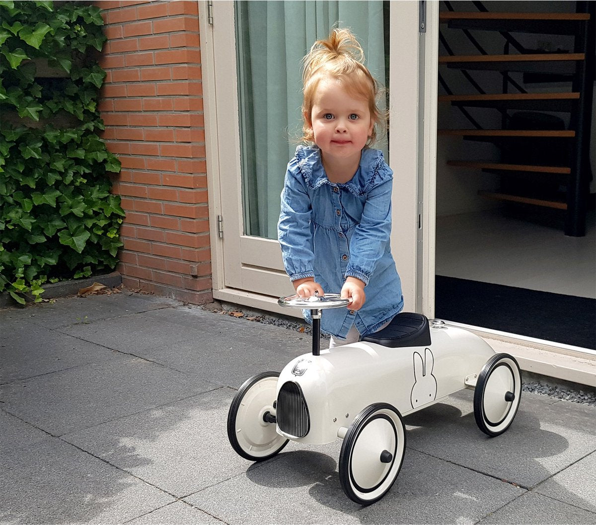 Kind rijdt op Nijntje auto buiten, ideaal cadeau voor verjaardag vanaf 2 jaar, vintage loopauto design