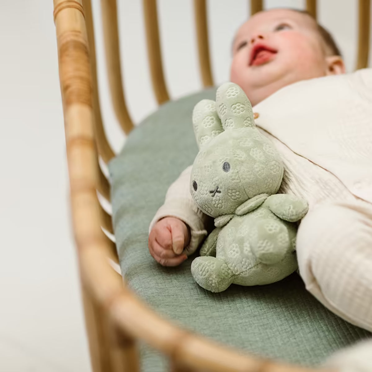 Liggende baby met groene Nijntje knuffel Green Flower 20cm van zacht pluche, schattig baby knuffelvriendje.