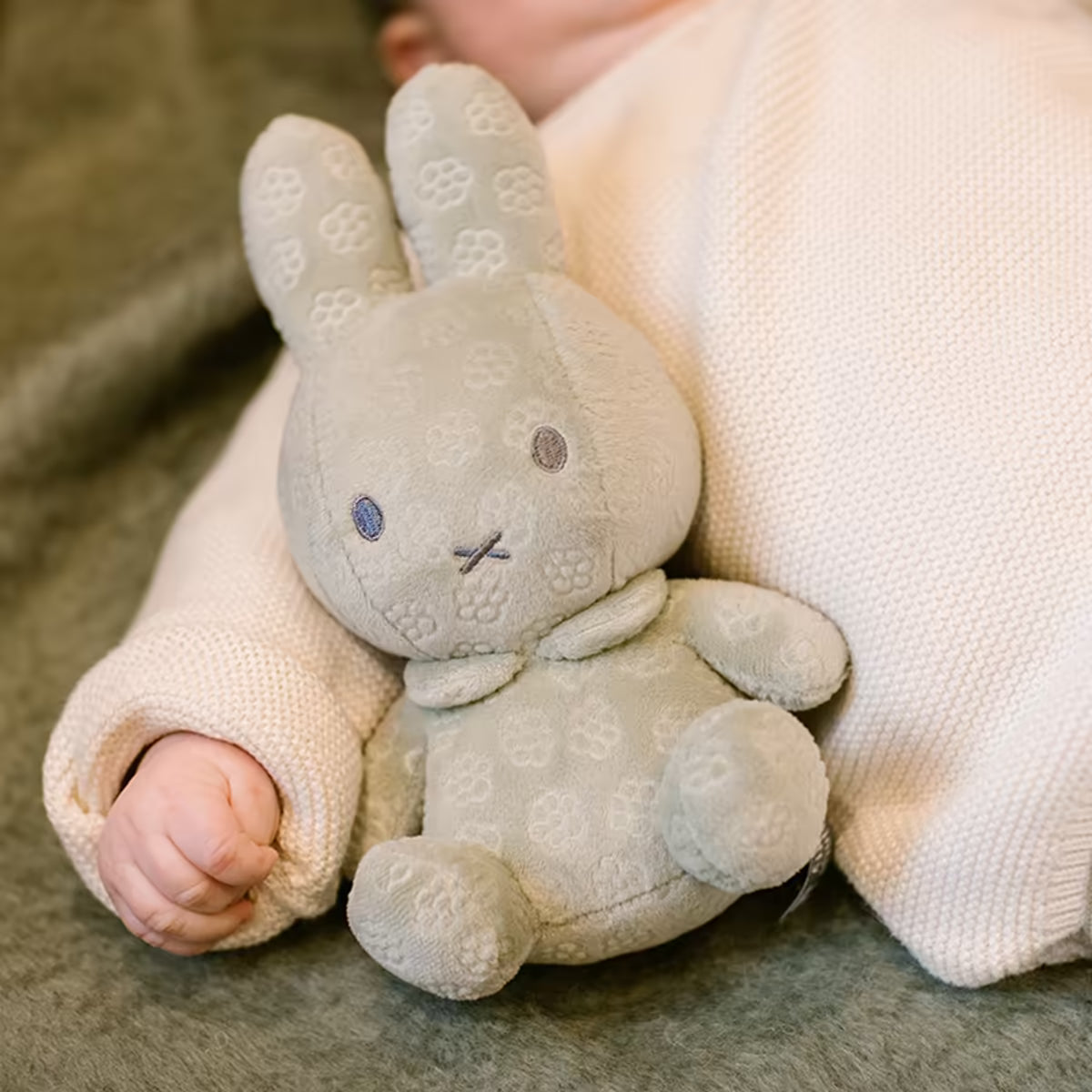 Baby knuffelt met groene Nijntje knuffel Green Flower 20cm, een zacht kraamcadeau voor pasgeboren kindjes.