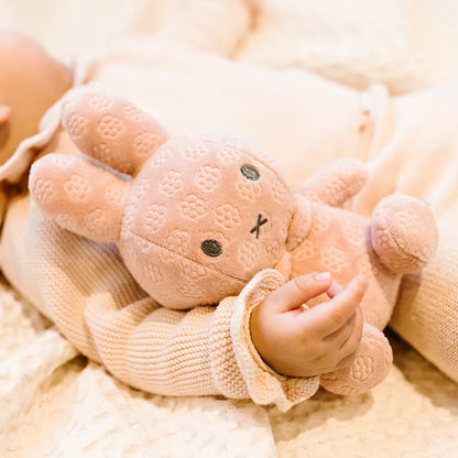 Baby ligt met Nijntje knuffel Pink Flower 20cm, zachte pluche knuffel en sensorisch speelgoed.