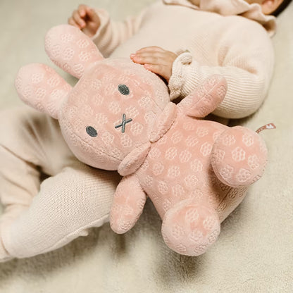 Liggende baby knuffelt roze Nijntje Knuffel 30cm, heerlijk zacht pluche en geschikt als sensorisch speelgoed.