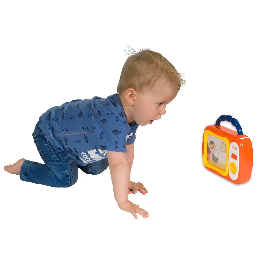 Baby kijkt aandachtig naar Nijntje mijn eerste TV, een vrolijk sensorisch speelgoed met kleurrijke beelden.