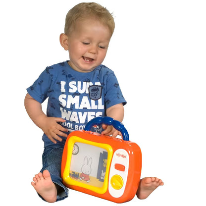Baby zit op de grond en speelt met Nijntje mijn eerste TV, kleurrijk en veilig speelgoed vanaf 12 maanden.