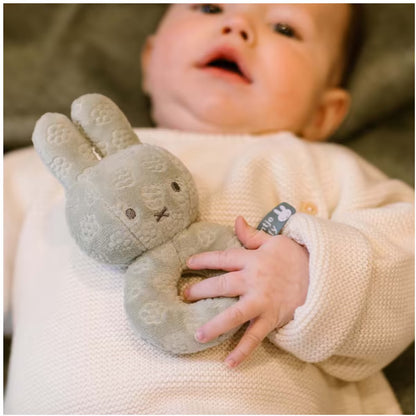 Baby houdt Nijntje Rammelaar Green Flower stevig vast, schattig sensorisch speelgoed en ideaal baby cadeau.