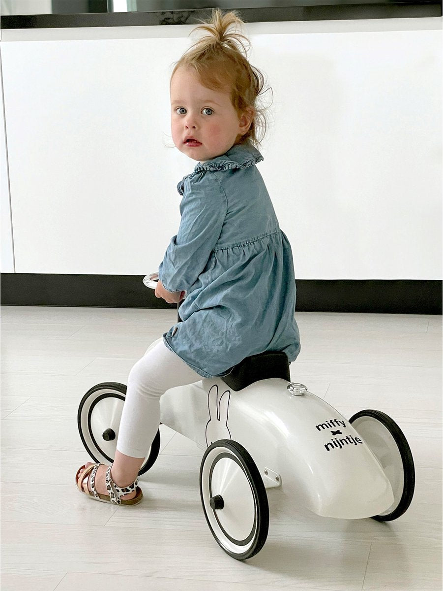 Peuter speelt met Nijntje retro loopauto binnenshuis, educatief speelgoed voor motorische ontwikkeling