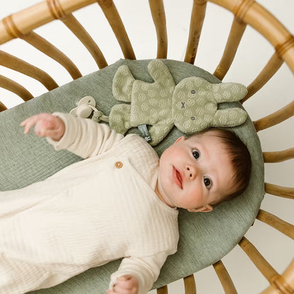 Baby in ledikant naast het Nijntje Speendoekje green flower, een lief baby cadeau en praktische speenknuffel.