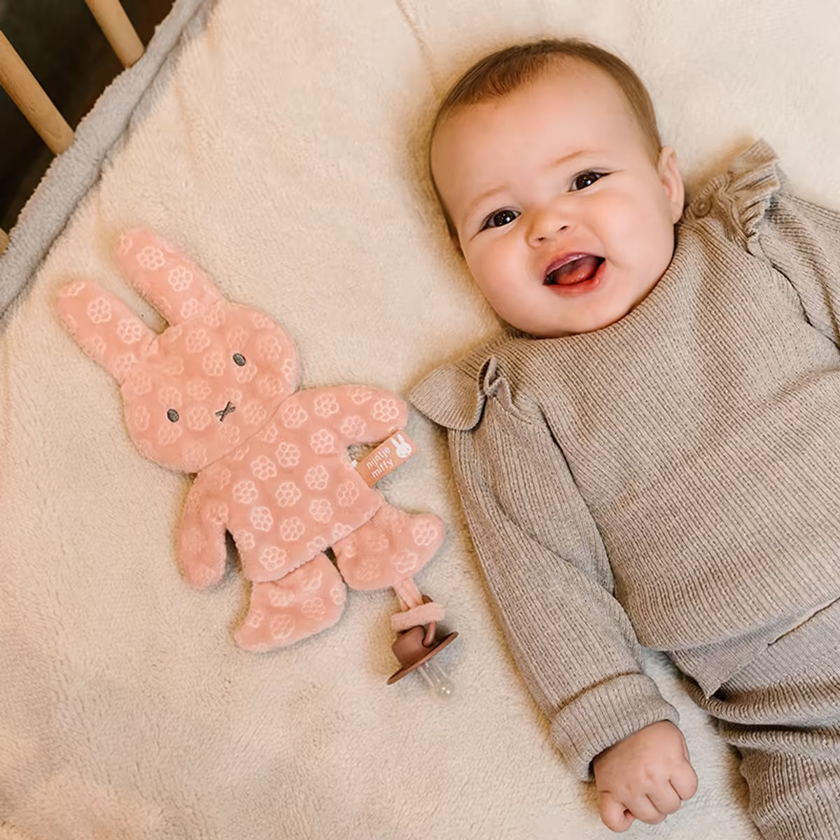Lachende baby met Nijntje Speendoekje Pink Flower, schattige speenknuffel ideaal als kraamcadeau voor newborn.