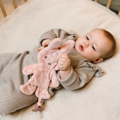 Baby spelend met Nijntje Speendoekje Pink Flower, zacht knuffeldoekje dat speenhouder en speenknuffel combineert.