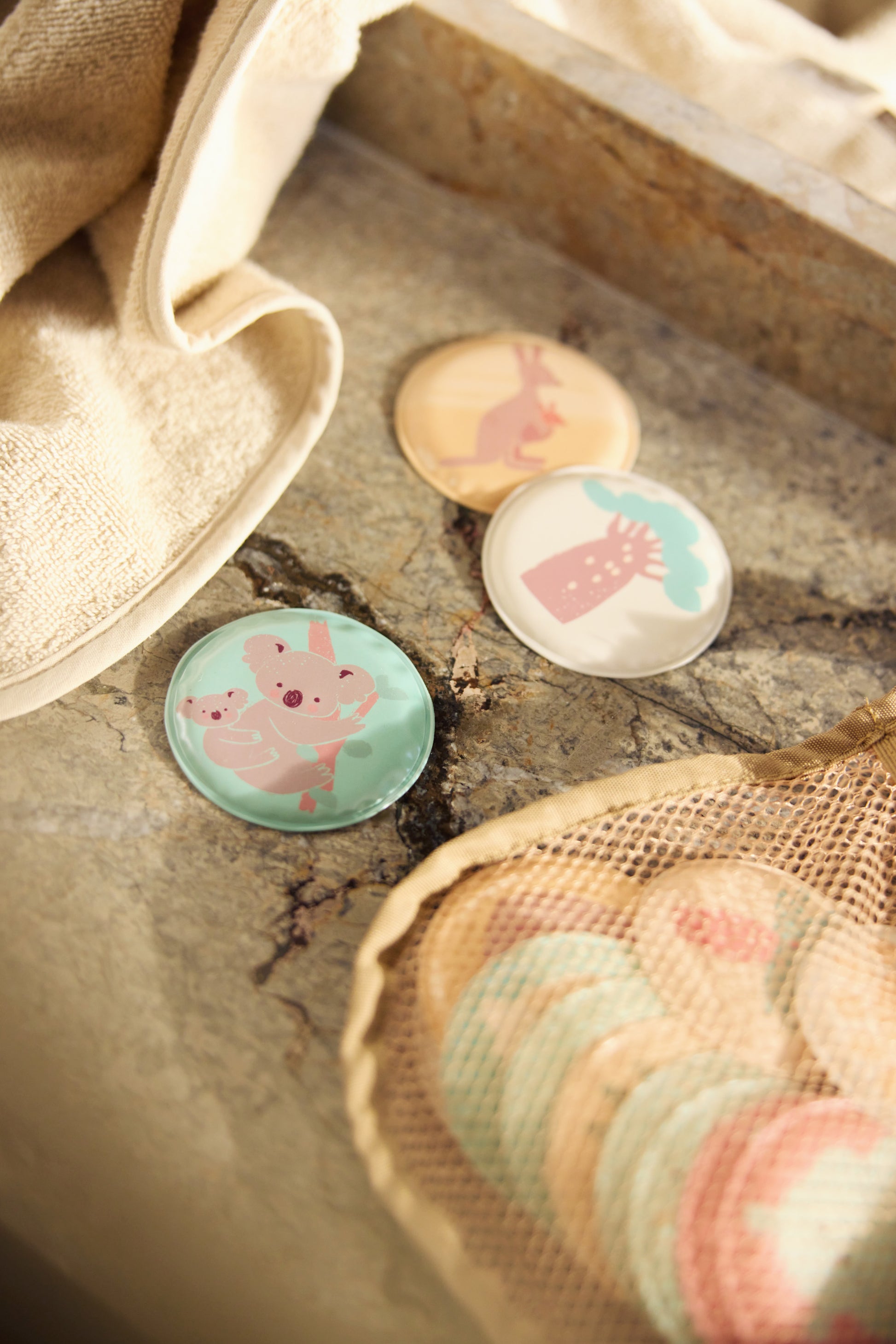 Opbergen badspeelgoed detail met Jollein Kangaroots memoryschijfjes en crèmekleurig washandje