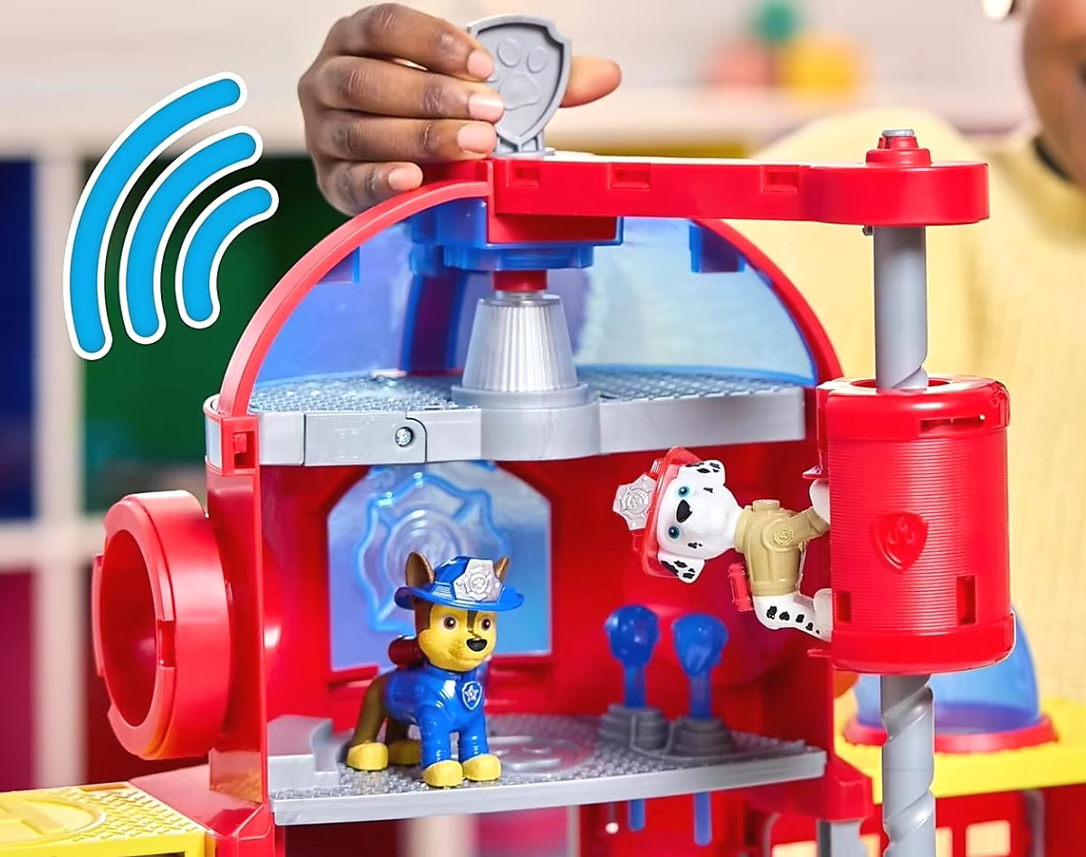 Kind speelt met Paw Patrol Fire Rescue Fire station, met Chase PAW Patrol figuur in rood-blauw speelhuis.