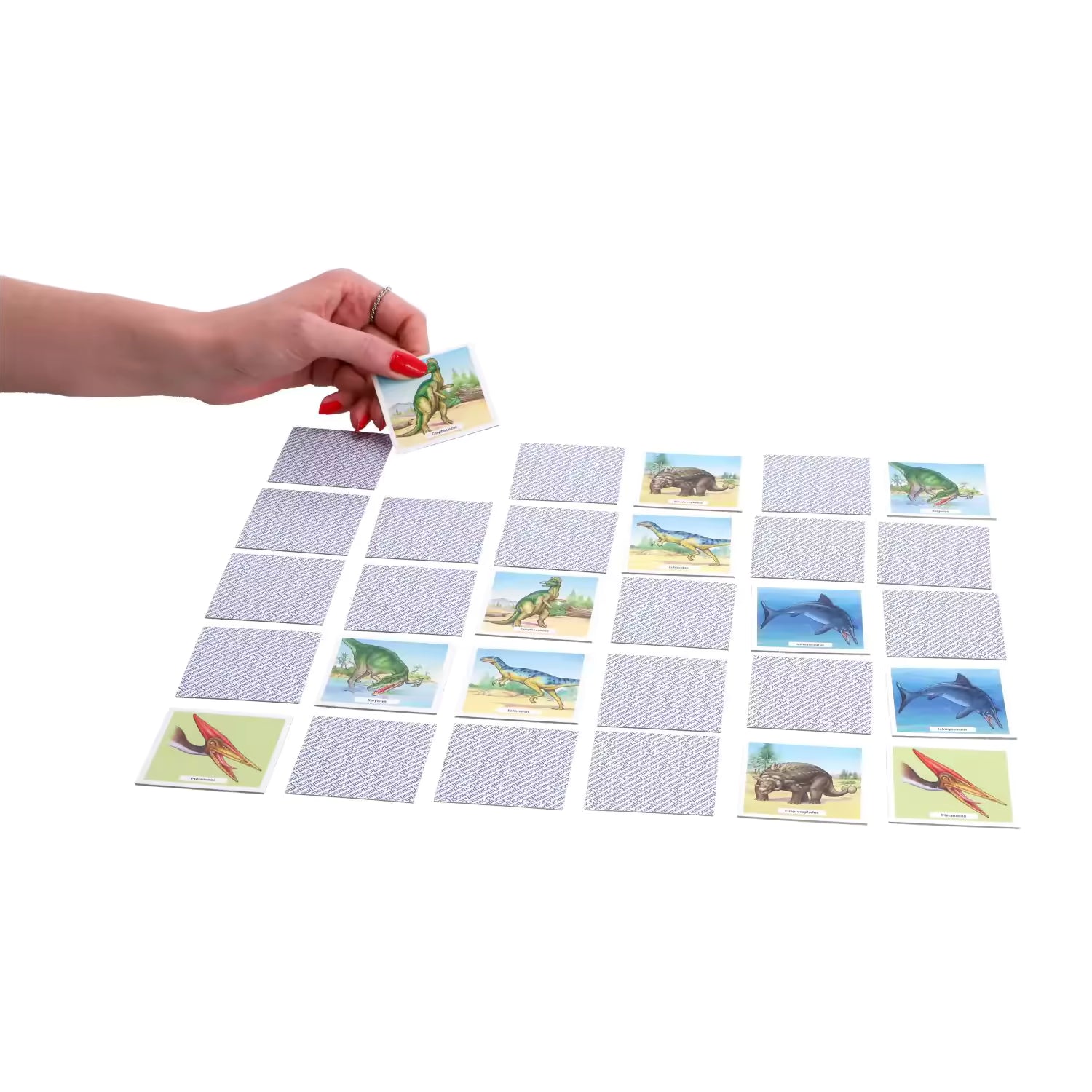 Hand draait Ravensburger dinosaurus memory kaart om tijdens spel, kindvriendelijk en leerzaam voor peuters.