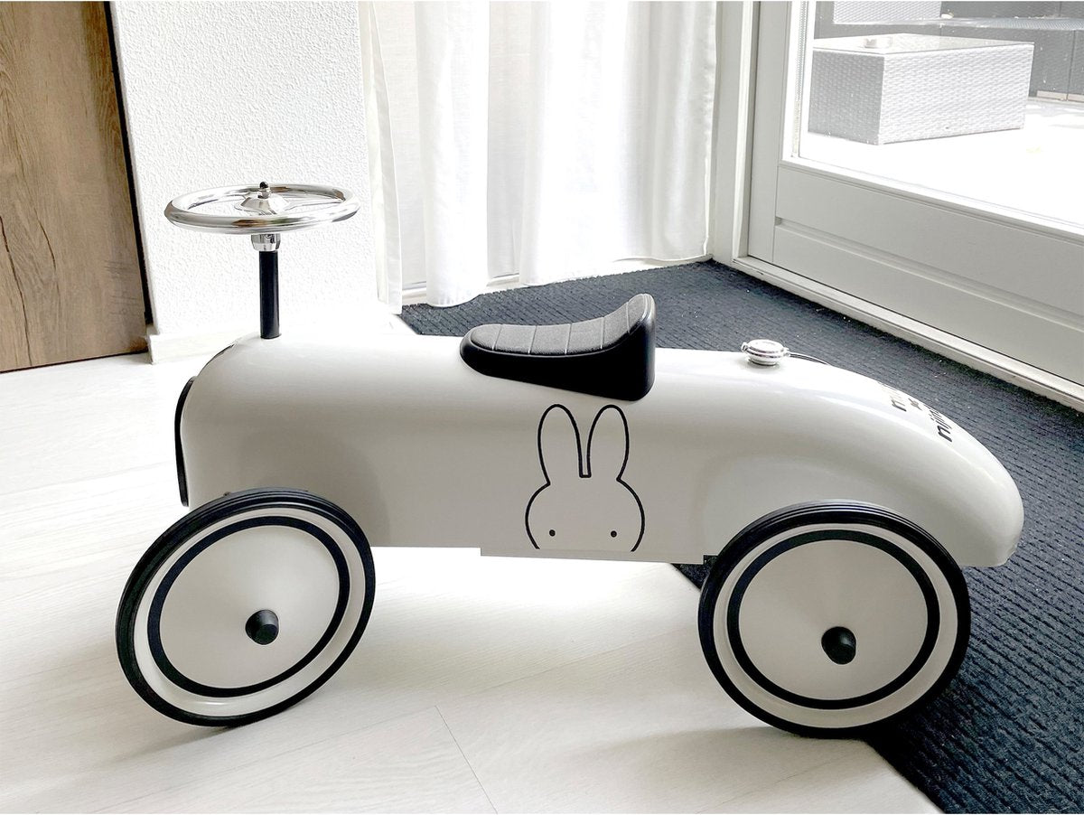 Nijntje retro loopauto bovenaanzicht binnenshuis, wit met zwarte wielen en ergonomisch zadel voor peuters
