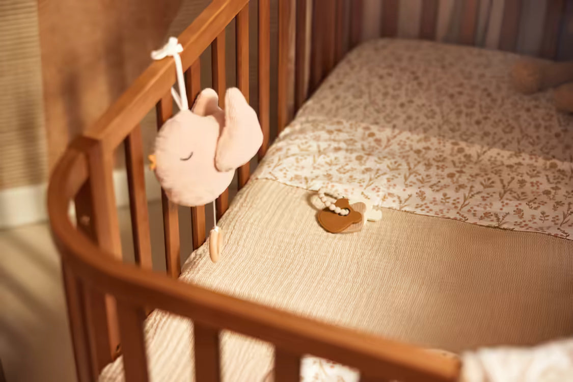 Roze Jollein Muziekdoosje Lovely Birds hangt aan houten ledikant, ideaal muziekdoosje baby of kraamcadeau met stijl.