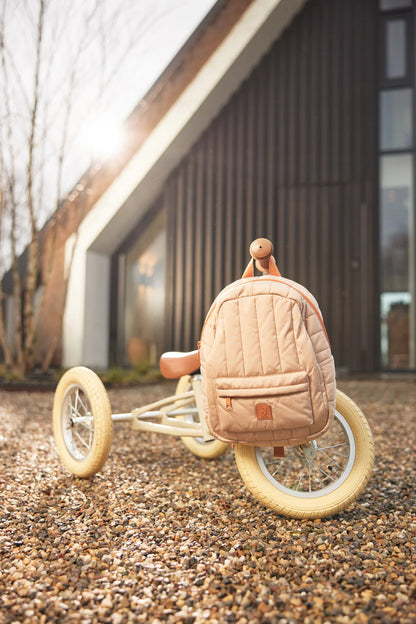 Rugzak Jollein biscuit op houten loopfiets buiten, ideale kleine rugzak voor peuters en kleuters