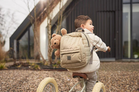 Rugzak kinderen Jollein Puffed olive green gedragen door peuter op loopfiets met knuffel
