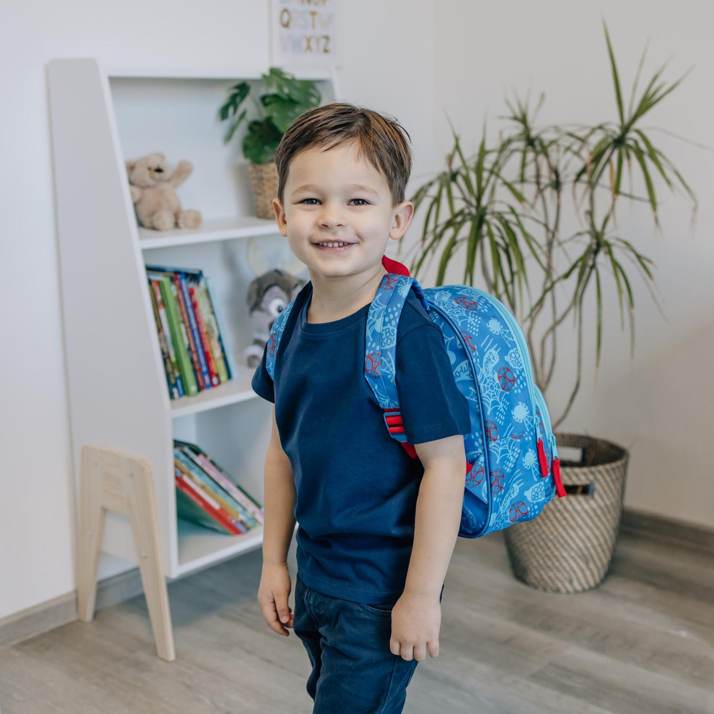 Rugzak kinderen gedragen door jongen in speelkamer, blauwe Spiderman rugzak ideaal voor back to school