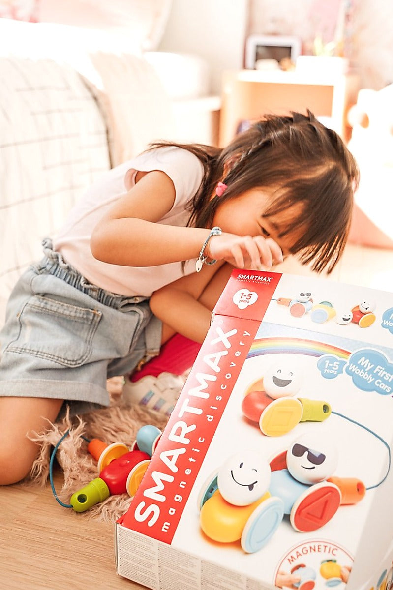 Peuter met SmartMax My First Wobbly Cars SMX 233 verpakking, magnetisch speelgoed vanaf 1 jaar