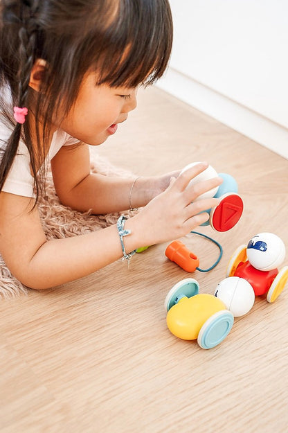 Kind speelt met SmartMax My First Wobbly Cars SMX 233 open ended speelgoed op houten vloer