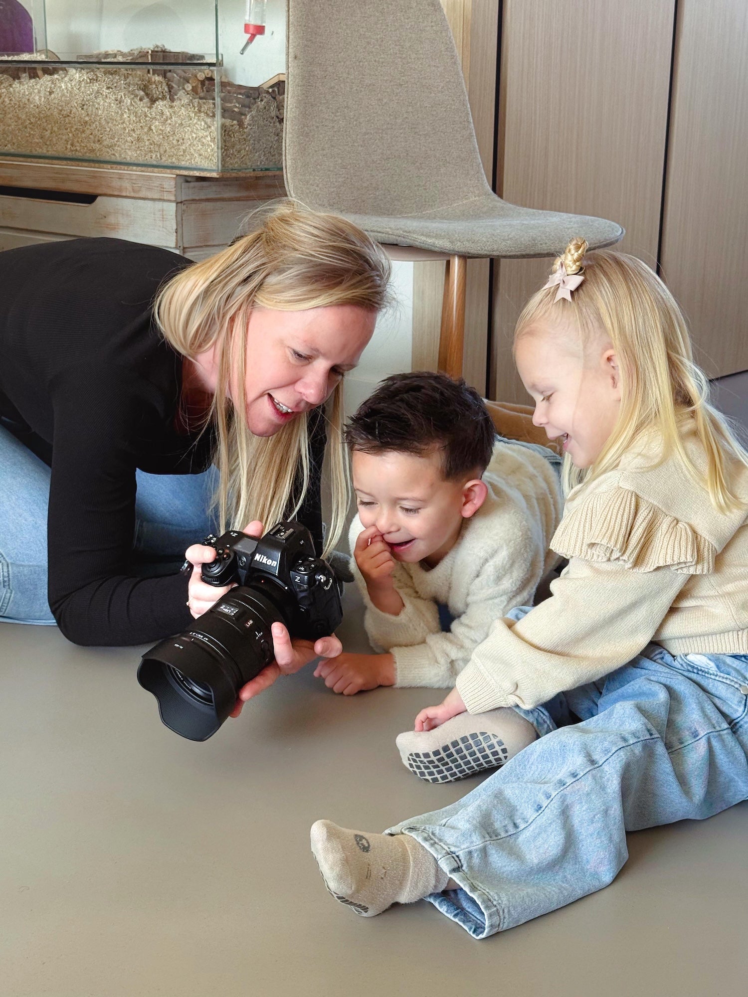 Fotograaf Cindy Jeurissen laat twee jonge kinderen de foto's zien op haar camera tijdens een Sproutz fotoshoot.