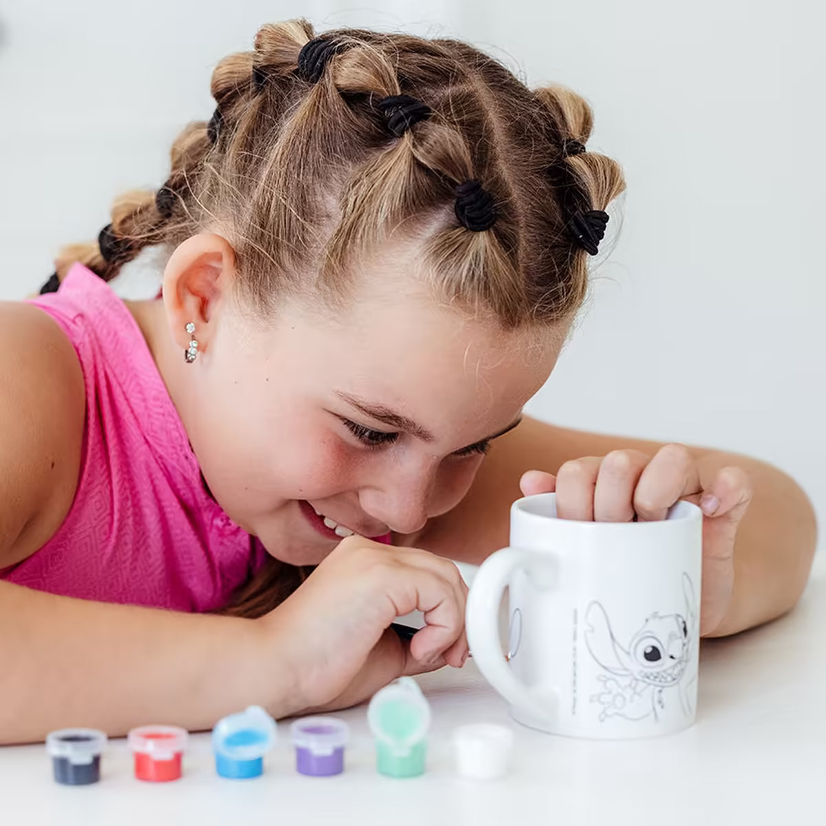 Meisje schildert witte Disney Stitch mok uit Totum set, creatief knutsel idee en leuke dingen om te knutselen voor kinderen.