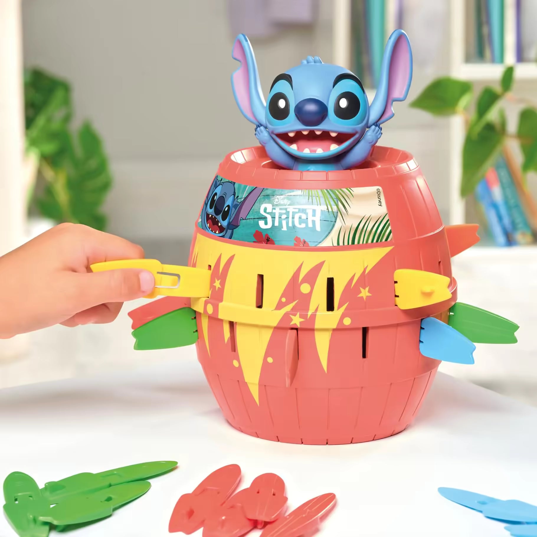 Stitch Pop Up spel waarbij kinderen gekleurde plankjes in rode ton plaatsen, leuk interactief spel speelgoed
