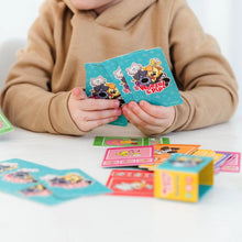 Kind houdt Woezel en Pip kwartet kaarten vast met kleurrijke illustraties, vrolijk junior kwartet voor kleuters.