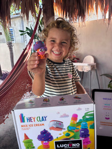 Meisje lacht en toont het zelf gemaakte Hey Clay Nice Ice Cream ijsje met oogjes.
