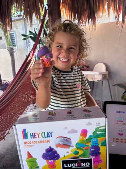 Meisje lacht en toont het zelf gemaakte Hey Clay Nice Ice Cream ijsje met oogjes.